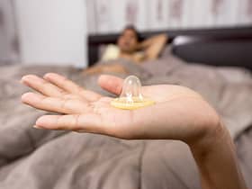 close up of woman holding condom